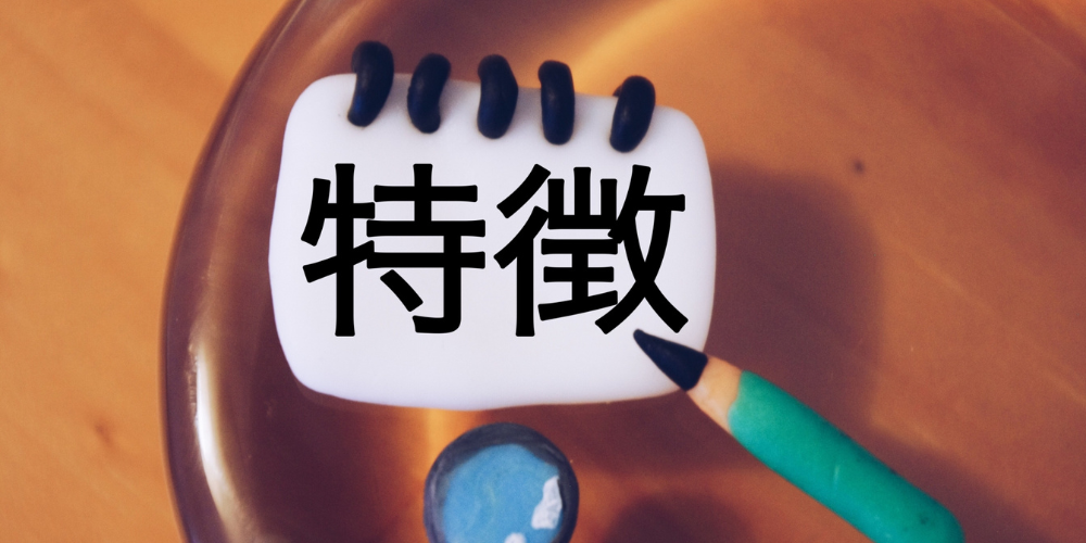 ノートと鉛筆の横に置かれた「特徴」の文字ブロック