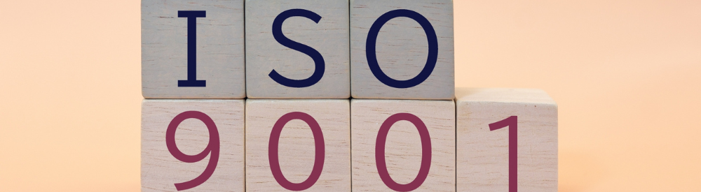 木製ブロックを積んで「ISO 9001」の文字を並べた品質マネジメント規格のビジュアル