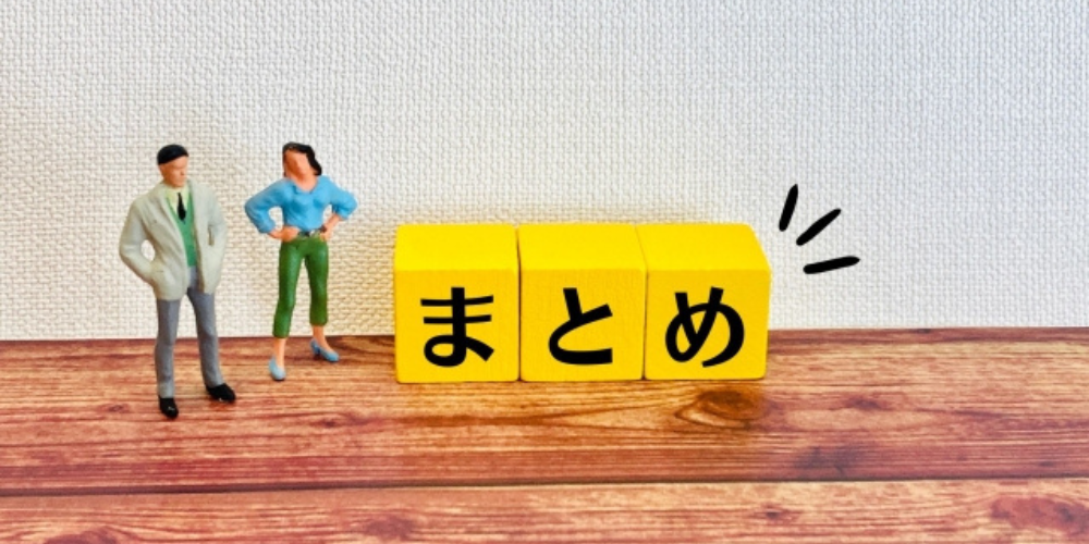木目調の床の上に「まとめ」と書かれた黄色いブロックと男女のフィギュアが立っている。