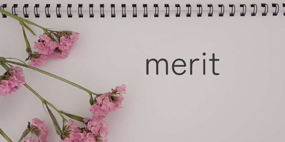 「merit」と書かれたノートと花の装飾