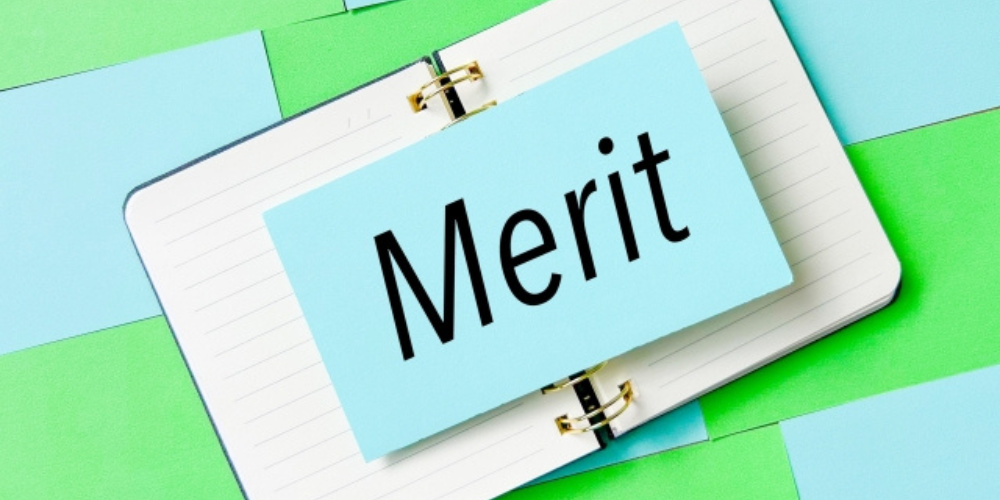 ノートの上に置かれた「Merit(メリット)」と書かれたカード。背景は明るい色の付箋紙