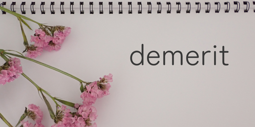 ノートに英字で「demerit」と書かれた画像