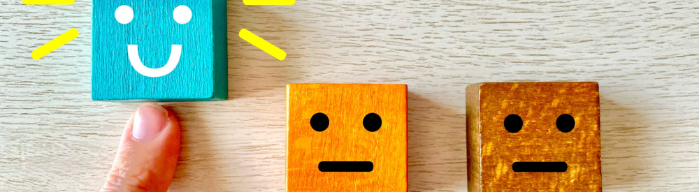 笑顔ブロックを指で選び、他2つは無表情の評価ブロック――良い評価を示唆するイメージ