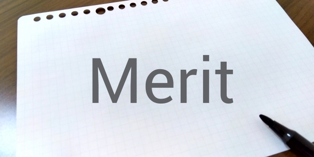 「ノートに『Merit』と書かれた文字とペン、利点やメリットを整理するイメージ」