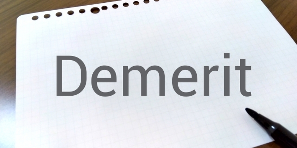 「ノートに『Demerit』と書かれた文字とペン、短所や注意点を整理するイメージ」