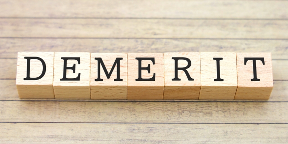 「木製ブロックに『DEMERIT』の文字が並ぶ、注意点や短所を示すイメージ」
