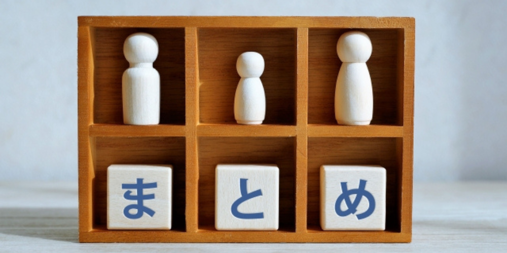木の仕切り棚に人形と「まとめ」と書かれたブロックが配置された整然としたデザイン。