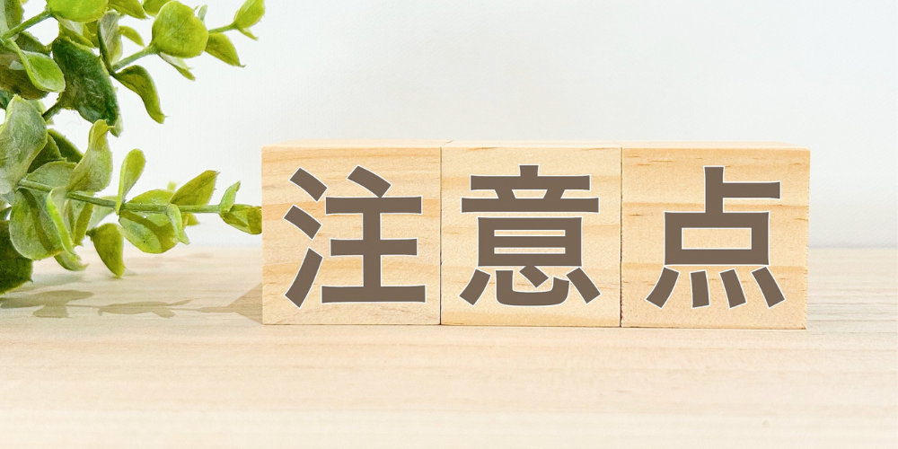 木製ブロックに「注意点」と書かれた表示と緑の葉