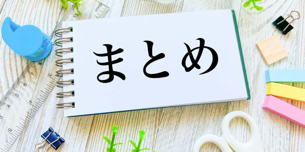 「まとめ」と書かれたノートを中心に、文具や観葉植物が配置された明るい構図