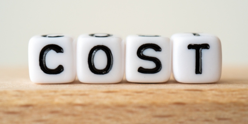 木のブロックに印字された文字「COST」が並ぶシンプルな構成