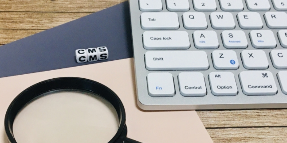 キーボードや虫眼鏡、CMSと書かれたサイコロが並ぶ、Web制作や分析を連想させる構成