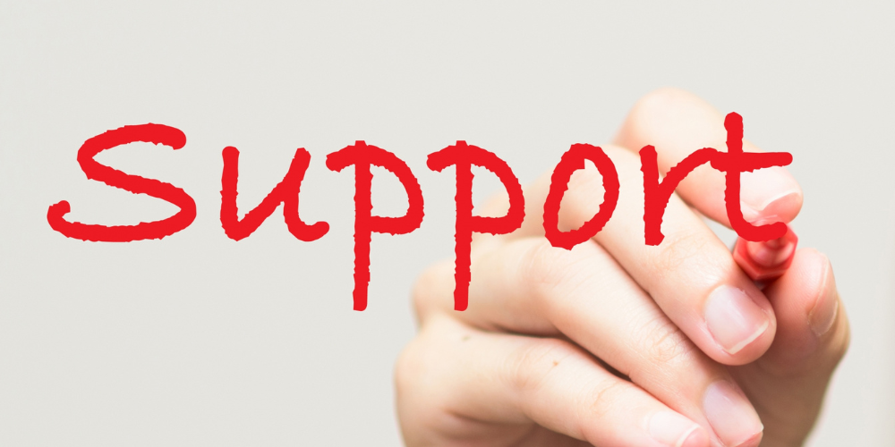 「Support」と書かれた文字を手で書いているイメージ