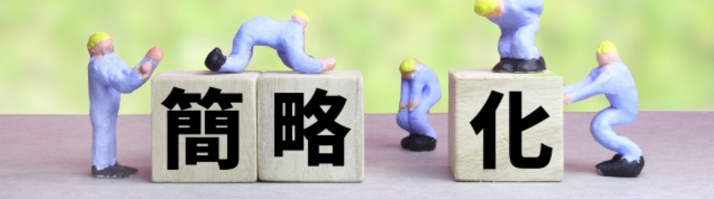 簡略化の文字が書かれたブロックを、青い作業服の人形たちが支える様子