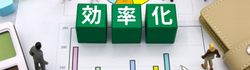 グラフ資料の上に「効率化」と書かれた緑のブロックが並び、小さな人形たちが配置されたビジネスイメージ