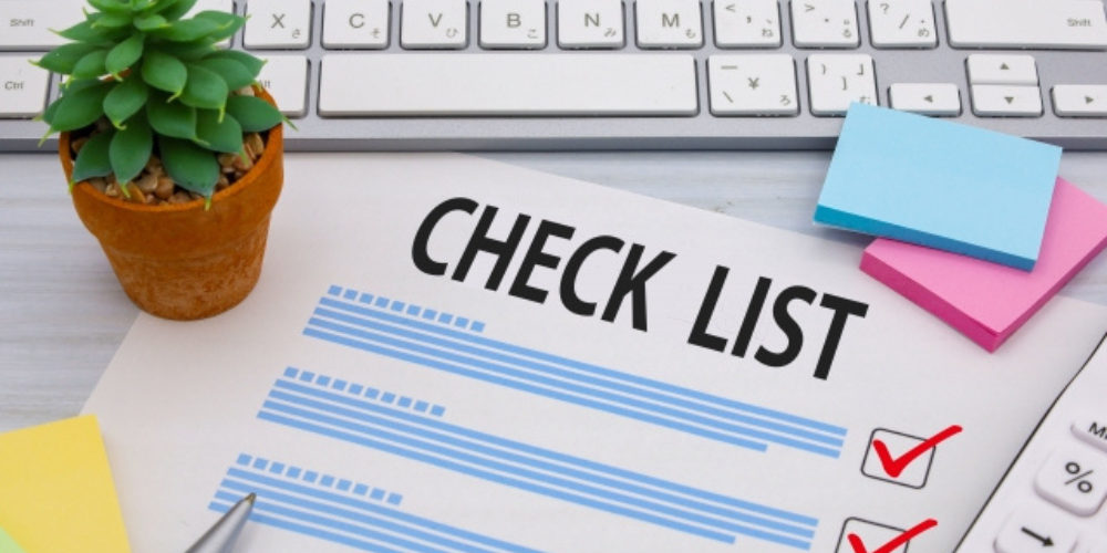 「CHECK LIST」と書かれた紙とチェックマーク、キーボードや文具が並んだ作業シーンのイメージ